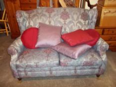 A DAMASK FABRIC FLORAL TWO SEATER SOFA WITH BRASS CASTORS, MATCHES LOT 807
