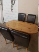 A SOLID PINE OVAL KITCHEN TABLE AND FOUR BROWN FAUX LEATHER CHAIRS