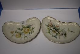 A PAIR OF BELLEEK KIDNEY SHAPED PLATES WITH DECORATIVE FLORAL DESIGN AND BLACK MARKS TO BASE