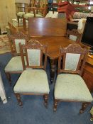 AN EDWARDIAN OAK EXTENDING DINING TABLE WITH ONE LEAF TOGETHER WITH FOUR CARVED OAK CHAIRS