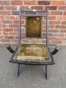AN EDWARDIAN EBONISED FOLDING CHAIR