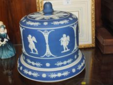 A WEDGWOOD STYLE BLUE AND WHITE JASPERWARE CHEESE DOME ON STAND, DECORATED WITH TYPICAL NEO
