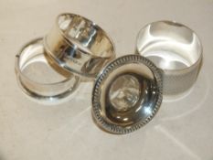 THREE HALLMARKED SILVER NAPKIN RINGS TOGETHER WITH A SILVER CANDLESTICK TOP (4)