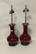 AN UNUSUAL PAIR OF ORIENTAL CERAMIC SANG DE BEOUF TWIN BULB LAMPS