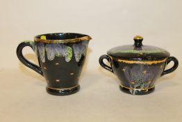 A BLACK VALLAURIS CERAMIC CREAM JUG AND SUGAR BOWL SET