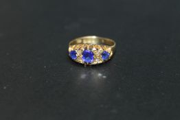 A HALLMARKED 18 CARAT GOLD SAPPHIRE AND DIAMOND RING - BIRMINGHAM 1910, set with three nicely
