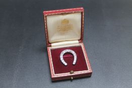 A DIAMOND SET HORSESHOE BROOCH, set with fifteen old cut diamonds totalling an estimated 2.7 carats,