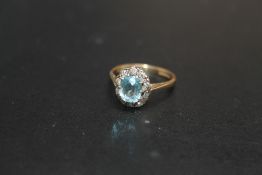 A HALLMARKED 9 CARAT GOLD AQUA MARINE TYPE RING, with diamond accent surround, approx weight 2g,