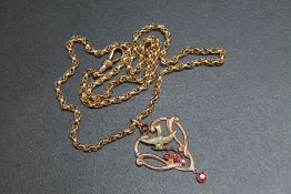 A 9CT GOLD EDWARDIAN STYLE GARNET SET PENDANT, upon an unmarked and untested yellow metal rollerball