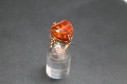 AN UNUSUAL RUSSIAN AMBER RING, with small pretty petal type inclusions and set in Russian hallmarked