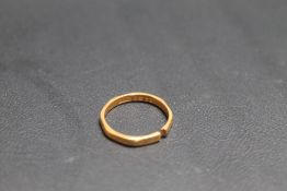A HALLMARKED 22 CARAT GOLD BAND, split, approx weight 2.2g