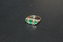 A HALLMARKED 9 CARAT GOLD THREE STONE EMERALD AND DIAMOND RING, approx weight 2.5g, ring size L