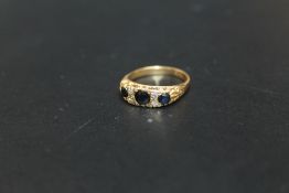 A HALLMARKED 9 CARAT GOLD THREE STONE SAPPHIRE AND DIAMOND RING, approx weight 4.3g, ring size L
