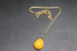 A RUSSIAN 875 GOLD HALLMARKED AMBER 'TEAR DROP' PENDANT, on similar marked chain, pendant H 2.5 cm