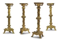 A SET OF FOUR GILT BRASS GOTHIC REVIVAL CANDLESTICKS, FRENCH OR ENGLISH