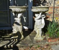 A pair of stone composition figural planters or bird baths