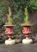 A pair of red painted cast iron models of the Borghese vase