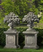A pair of sculpted limestone pier finials modelled as vases of fruit