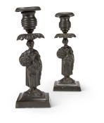 A PAIR OF PATINATED BRONZE CANDLESTICKS