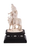 Y An Indian carved ivory figure of the infant Krishna playing the flute