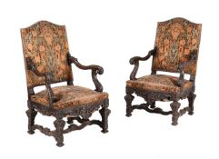 A pair of carved walnut and upholstered armchairs in mid 18th century style