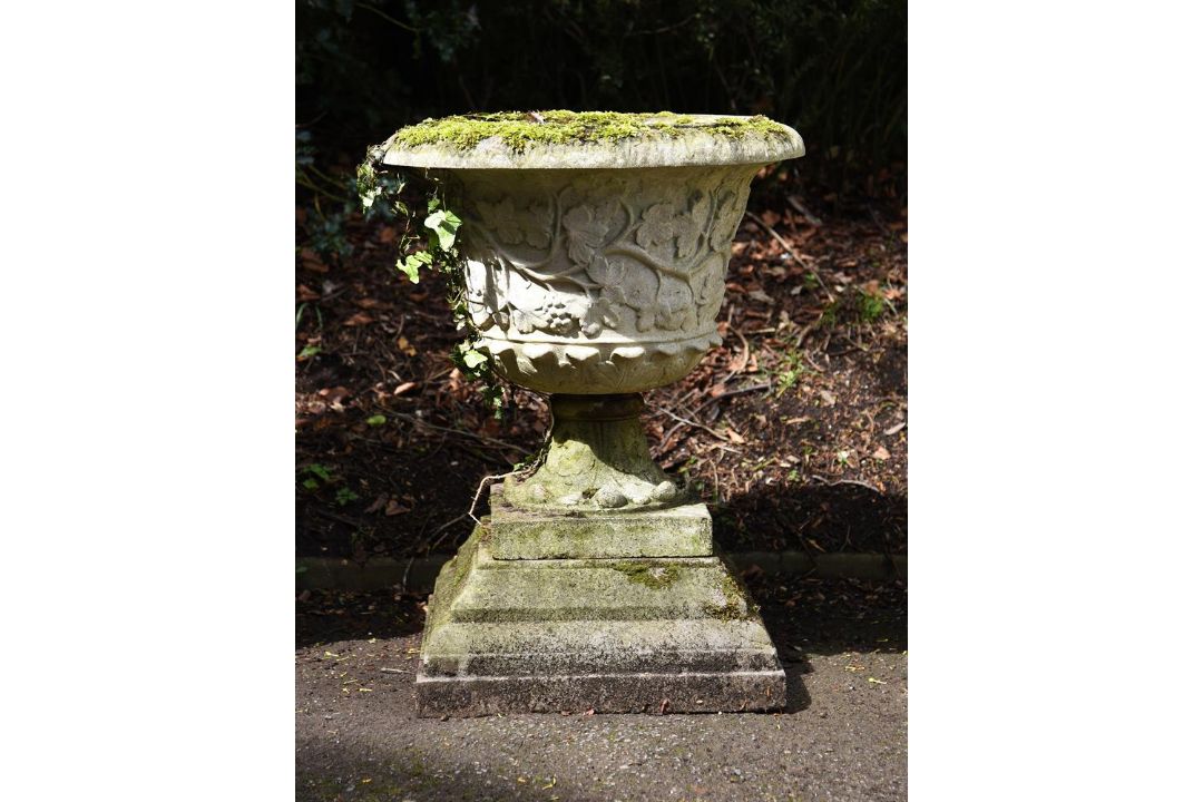 A composition stone urn on stepped base
