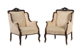 A pair of late Victorian mahogany and upholstered armchairs