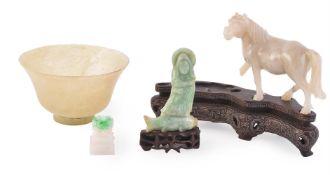A Jadeite carving of a figure standing on a fish