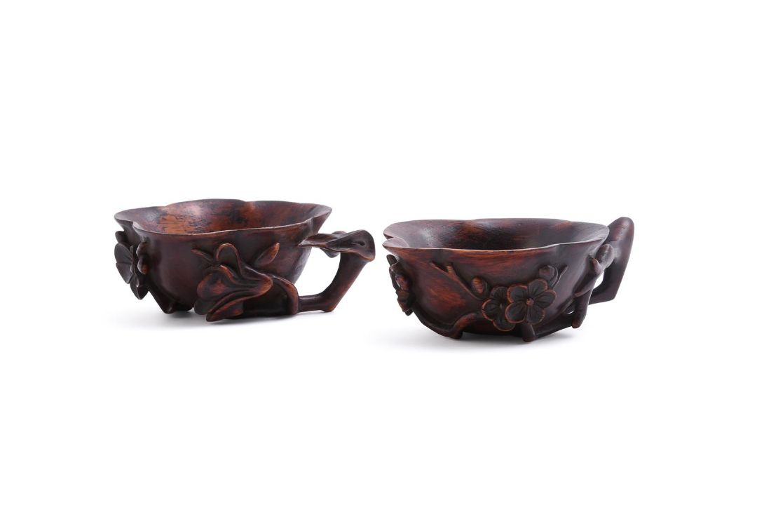 A pair of Chinese Huanghuali 'prunus and lotus' cups - Image 1 of 4