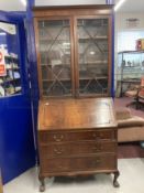 20th cent. Mahogany bureau bookcase with glazed top section, the whole supported on ball and claw