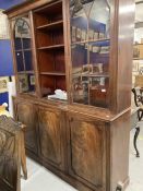 Late George III mahogany library bookcase, the moulded cornice above three glazed doors with