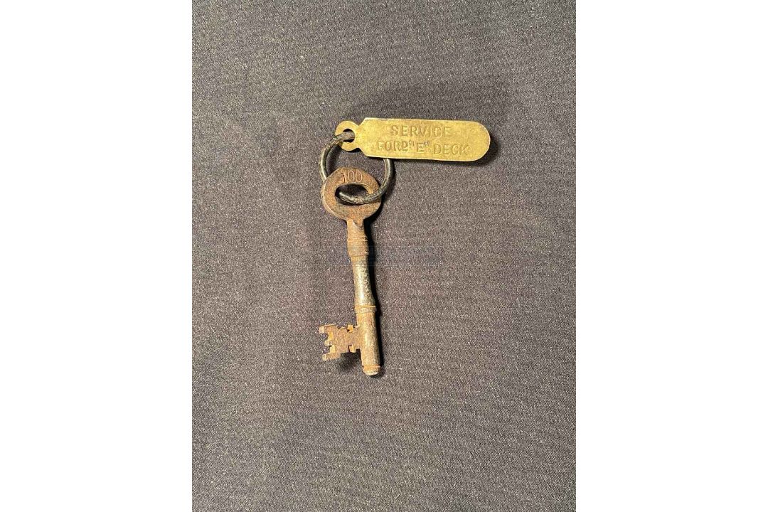 R.M.S. TITANIC: White Star Line company key and ring with brass tag stamped "SERVICE FORd "E" Deck". - Image 1 of 2