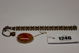 A hard stone agate oval pendant in yellow metal mount together with a yellow metal bracelet.