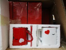 Twelve boxed as new Kissing Mug sets.