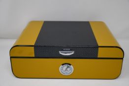An as new Savinelli 1876 Yellow Lacquered Humidor in carbon fibre (RRP €140).