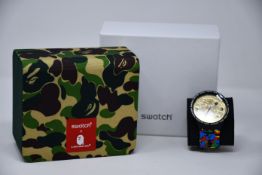 A boxed as new Swatch X Bathing Ape watch.