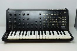 A pre-owned Korg MS-20 Mini Synthesizer with power supply and box.