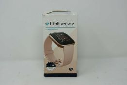 A pre-owned Fitbit Versa 2 Smart Watch in Copper Rose Aluminum with Petal Band (charger, small and