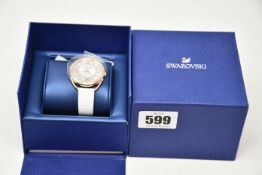 One boxed as new Swarovski watch with white leather strap.