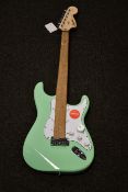 A boxed as new Fender Squier Affinity Series Stratocaster electric guitar in surf green.