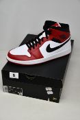 A boxed as new pair of Nike Air Jordan 1 Mid white and red basketball shoes (UK 11).