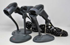 Three pre-owned Honeywell Voyager 1250g USB Barcode Scanners (P/N: 1250g-2) with stands.