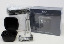 A boxed as new Piqo Smart Android Mini Projector (UK plug adaptor required) (Box sealed) with fabric