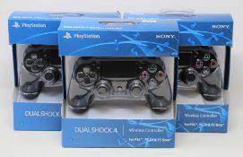 Four boxed as new Sony PlayStation DUALSHOCK 4 Wireless Controllers in Black (some damage to box).