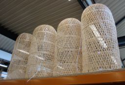 Four large wicker light fittings.