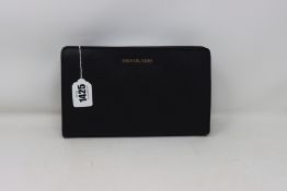 An as new Michael Kors Jet Set Travel crossbody clutch in black.