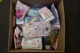 A box of assorted beauty accessories to include eye lash curlers, eyebrow razors, exfoliating