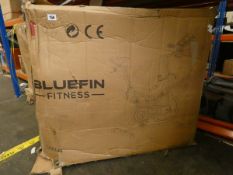 A boxed Bluefin Fitness Tour Spin exercise bike in silver.