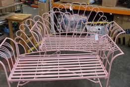 Two pink garden metal benches.