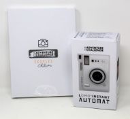 A boxed as new The Adventure Challenge & Lomography Lomo Automat Instant Camera (Box opened) and